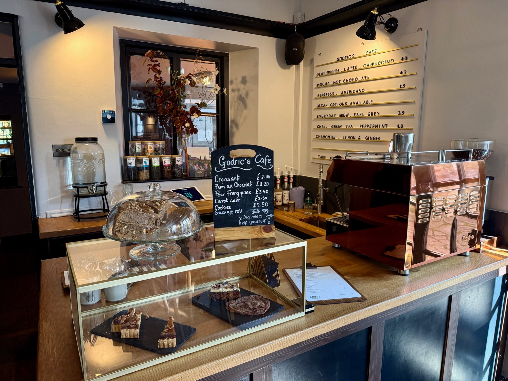 Godric's Café counter with homemade cakes and coffee